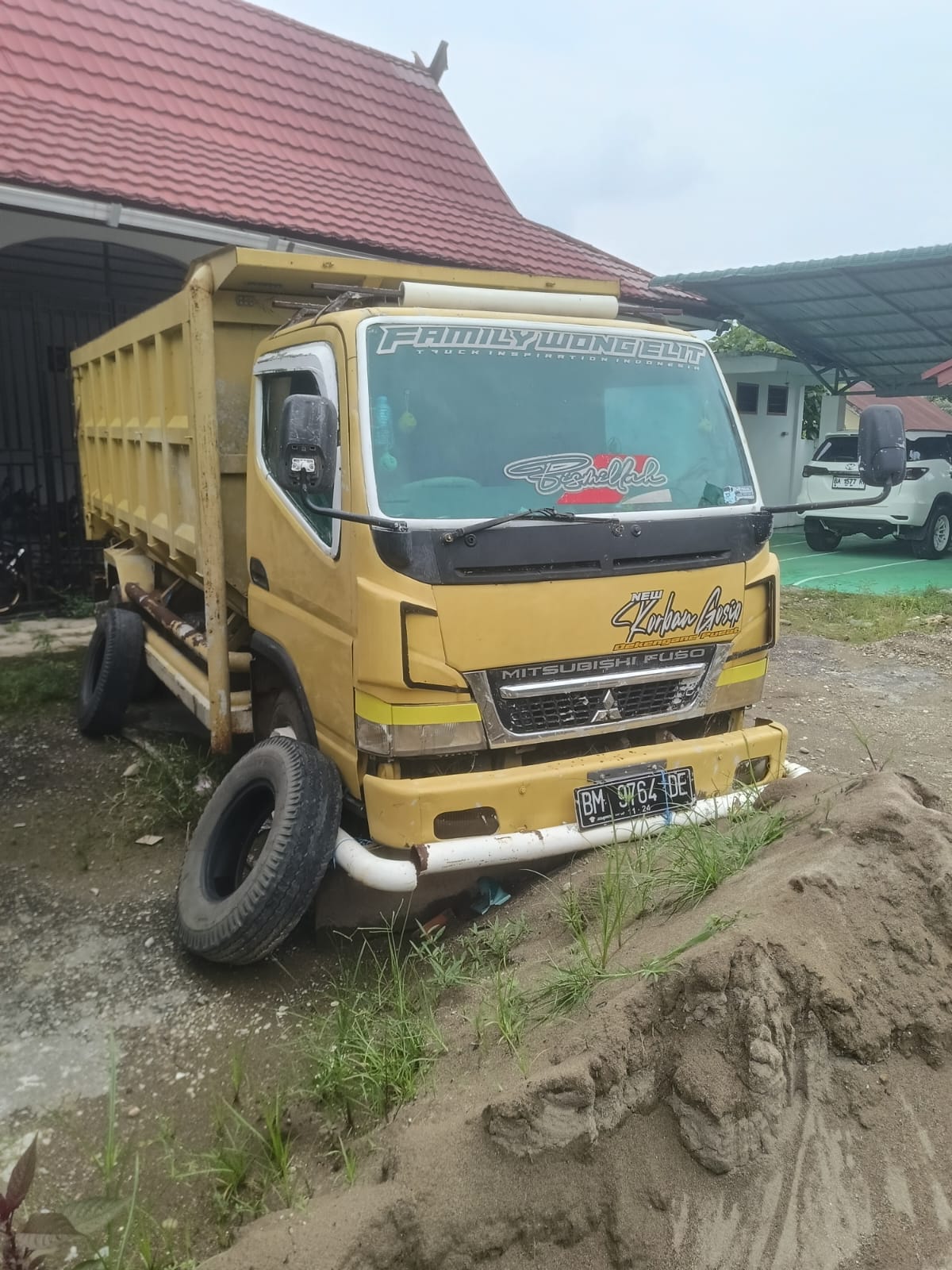 1 (satu) unit angkutan (darat) mobil mitsubishi canter warna kuning nomor polisi BM 9764 DE.