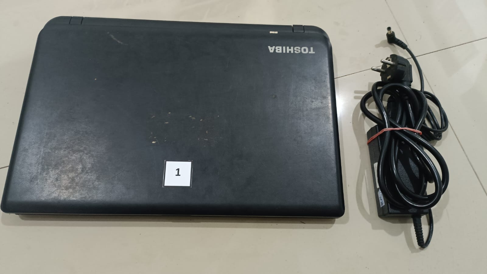 1 (satu) unit Laptop merk Toshiba berwarna hitam type Satelit C55t-B5249 dengan nomor seri XE155868P; 1 (satu) set alat cas Laptop Toshiba;