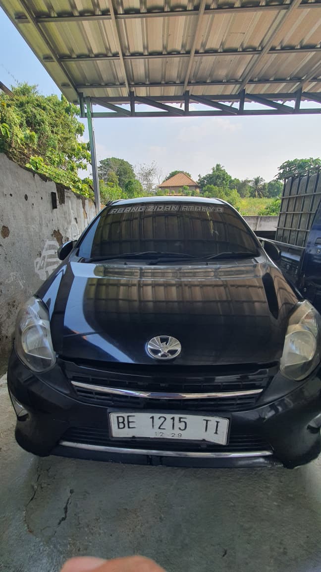mobil merk Toyota Agya warna hitam dengan nopol BE 1215 TI